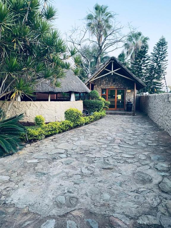 Stone pathway leading to the thatched entrance of Rafiq Luxury Apartments