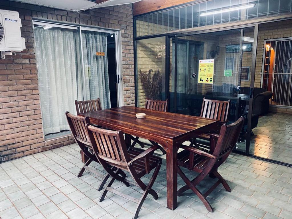 Private brick patio with a solid timber dining table and chairs