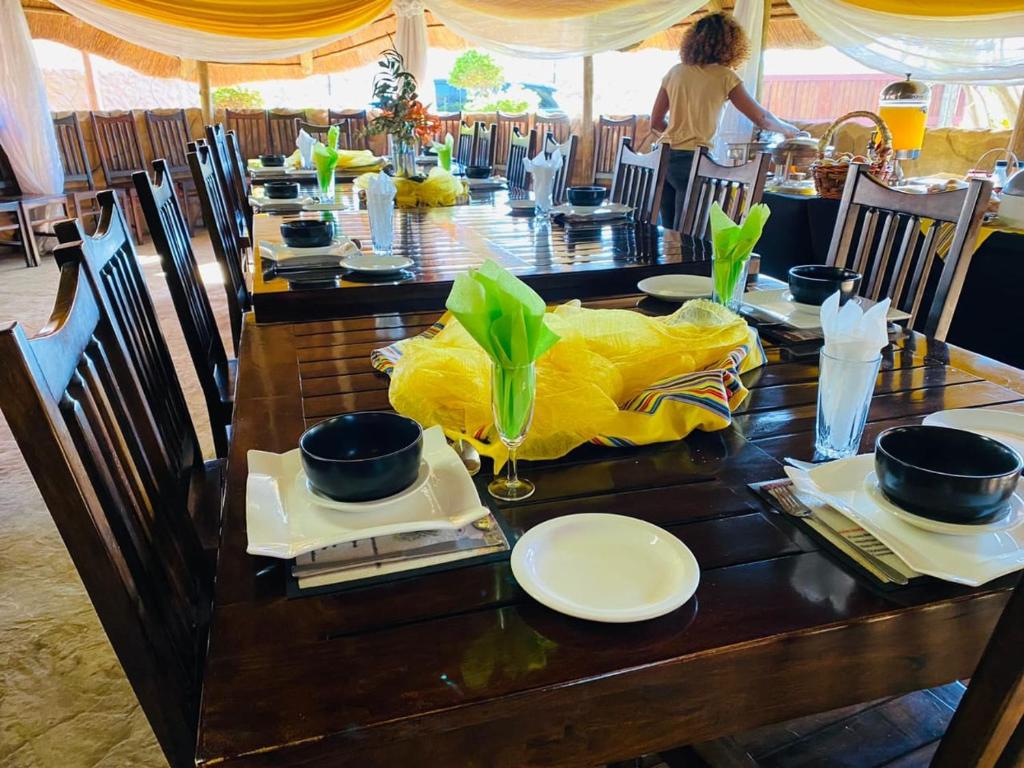 Elegant dining hall set for breakfast under a thatched roof